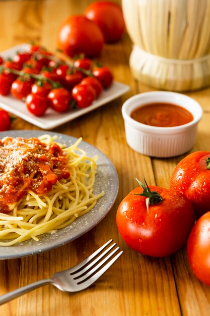 Plato de pasta con un tenedor en la mesa de madera