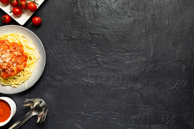 Plato de pasta con tomates en pizarra