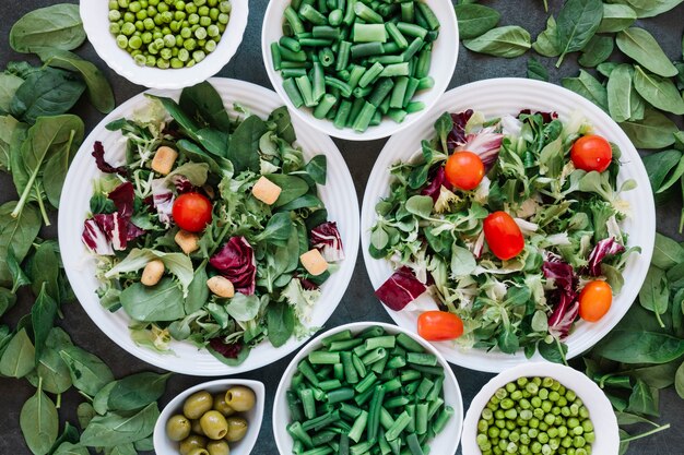 Plato plano de platos con ensaladas y judías verdes