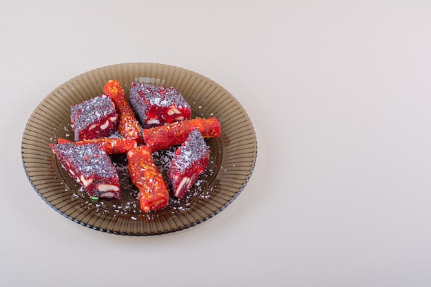 Plato de pulpas de frutas confitadas colocado sobre fondo blanco. Foto de alta calidad