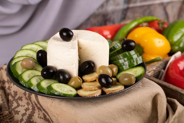 Plato de queso blanco con pepino y aceitunas