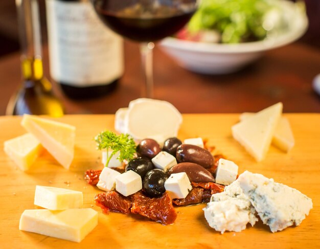 Plato de queso con una copa de vino tinto