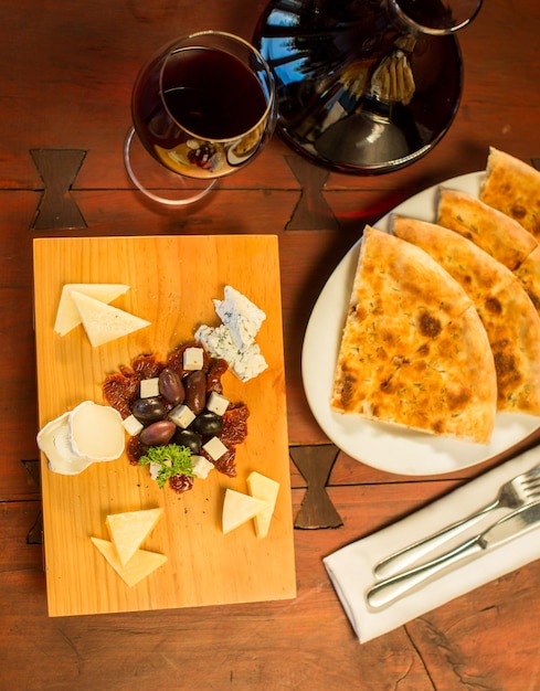 Plato de queso con una copa de vino tinto