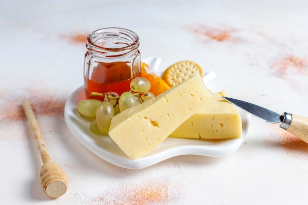 Plato de queso con delicioso queso tilsiter y bocadillos.