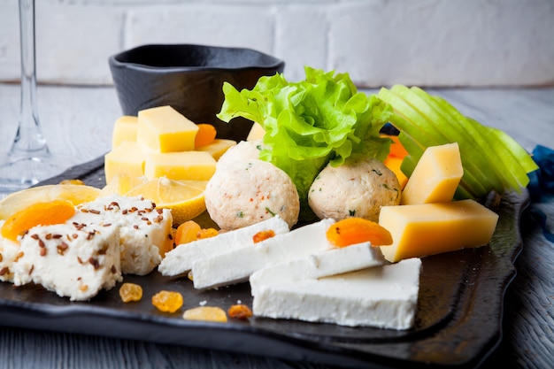 Plato de queso con ensalada de hojas y pasas y miel en el tablero de alimentos