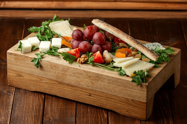 Plato de queso con frutas sobre la mesa