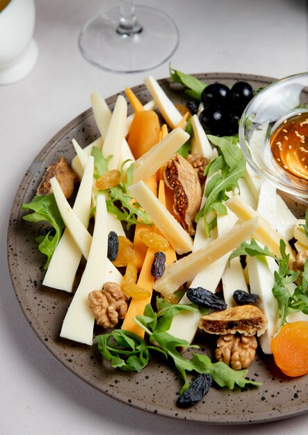 Plato de queso con nueces pasas rúcula y aceitunas