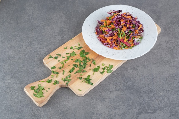 Plato de repollo picado y zanahorias sobre tabla de madera. Foto de alta calidad