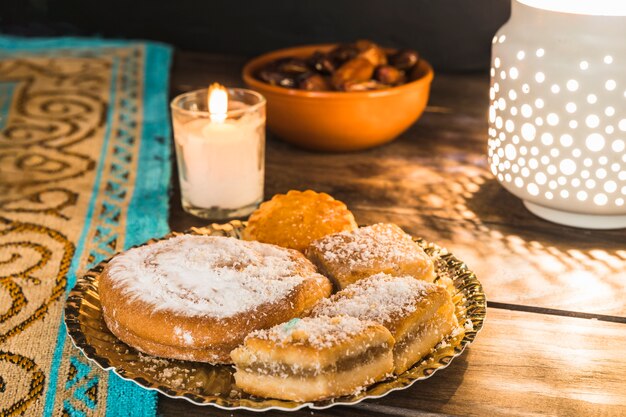 Plato con repostería cerca de vela