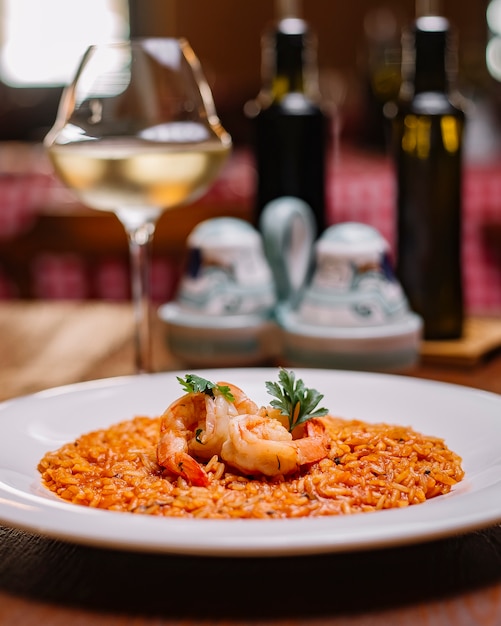 Un plato de risotto de mariscos con salsa de tomate.