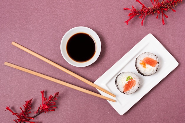 Plato con rollos de sushi y salsa de soja