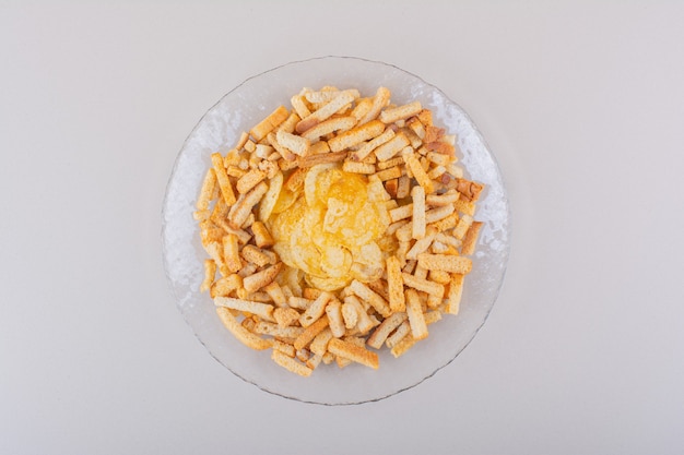 Plato de sabrosas galletas crujientes y patatas fritas sobre fondo blanco. Foto de alta calidad