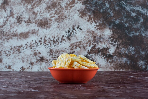 Un plato de sabrosos chips de queso en mármol.