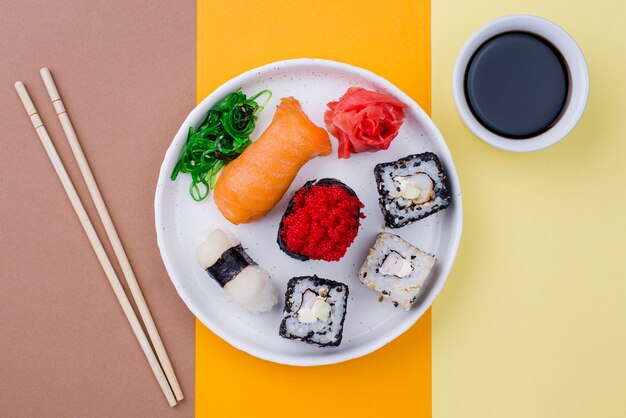 Plato con sushi y salsa en la mesa