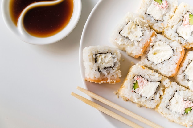 Plato de sushi con salsa y palillos