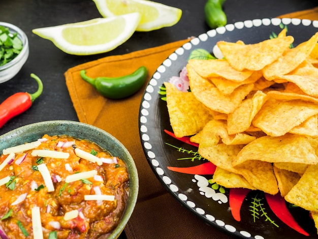 Plato con tacos junto a taza de guarnición y verduras.