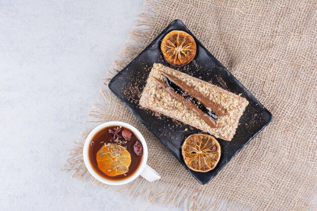 Plato de tarta casera con té de frutas sobre arpillera. Foto de alta calidad