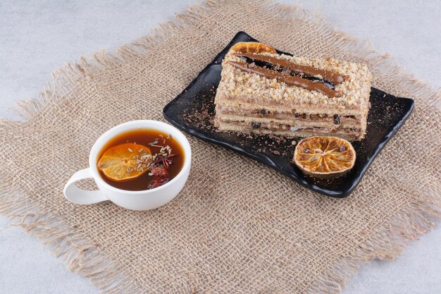 Plato de tarta casera con té de frutas sobre arpillera. Foto de alta calidad
