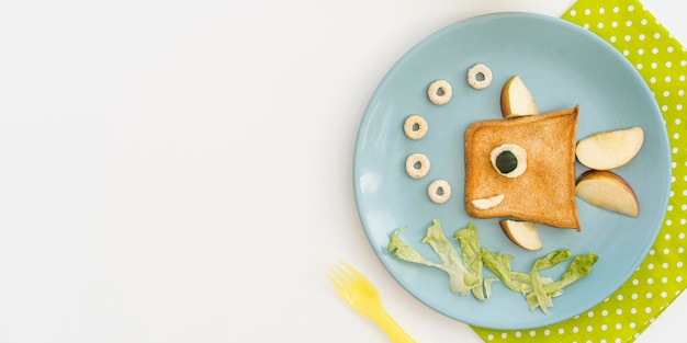 Plato con tostadas en forma de pescado con manzana con espacio de copia