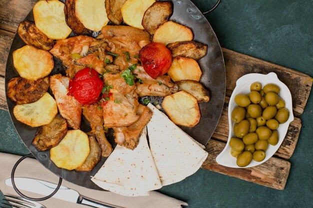 Plato tradicional azerbaiyano con carne a la parrilla y verduras servidas con aceitunas marinadas