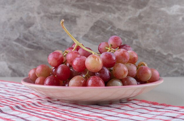 Plato de uvas sobre una toalla de mármol