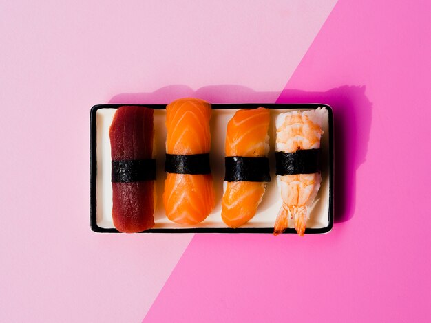 Plato de variaton de sushi sobre un fondo rosa