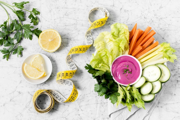 Plato de verduras con cinta métrica y salsa rosa