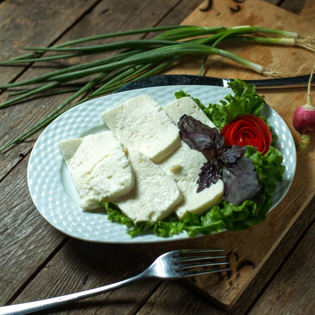 Foto gratuita plato de vista superior con queso con cebolla verde y albahaca