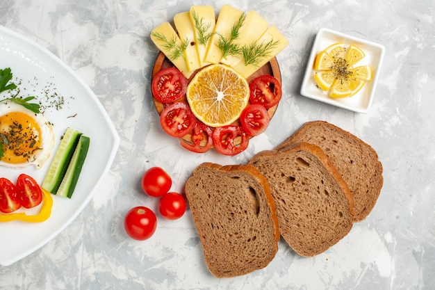 Plato de vista superior con verduras y verduras con queso y pan en un escritorio blanco claro verduras comida comida almuerzo desayuno