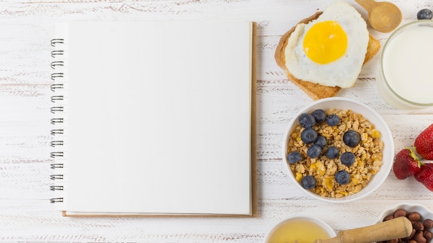 Foto gratuita platos desayuno junto a cuaderno