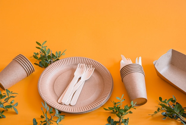 platos desechables ecológicos hechos de papel en una pared naranja