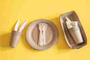Foto gratuita platos desechables ecológicos hechos de papel sobre un fondo naranja.