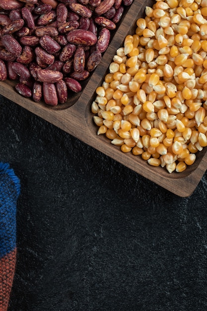 Platos de madera con frijoles rojos crudos y palomitas de maíz.