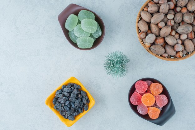 Platos de mermelada de azúcar con cuenco de madera lleno de nueces. Foto de alta calidad