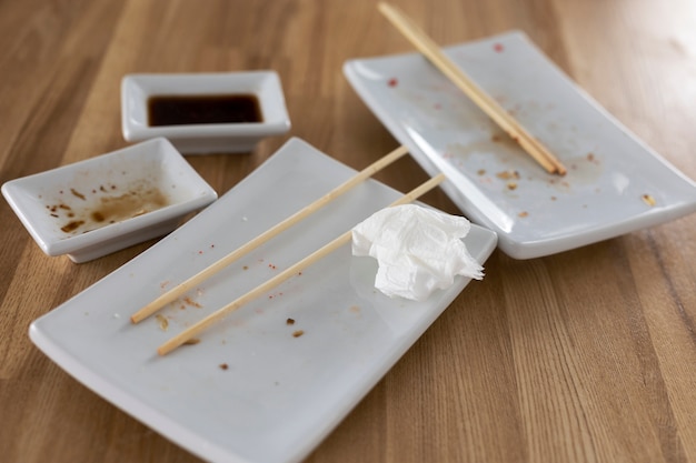 Platos y palillos sucios de alto ángulo en la mesa