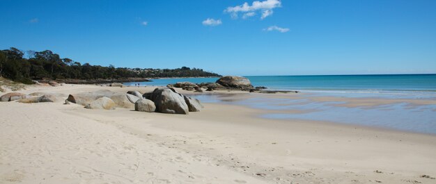 Playa de arena con algunas rocas