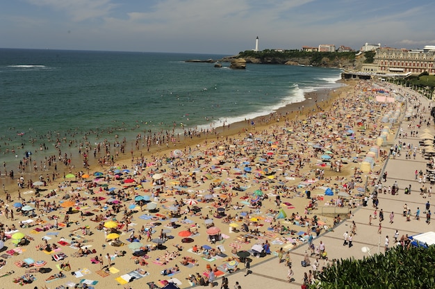 Playa llena de gente en temporada de verano, vista aérea