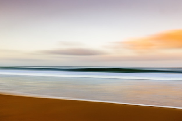 Foto gratuita playa durante la puesta de sol con efecto de movimiento.