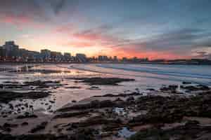 Foto gratuita playa durante una puesta de sol en gijón, españa