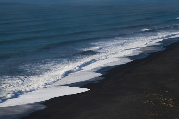 Playa rodeada por el mar bajo la luz del sol en Islandia