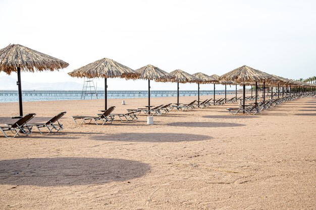 Playa vacía con tumbonas y sombrillas. Crisis turística durante la cuarentena.