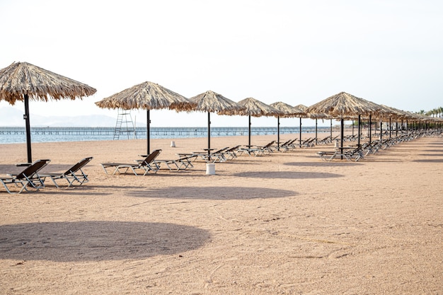 Playa vacía con tumbonas y sombrillas. Crisis turística durante la cuarentena.