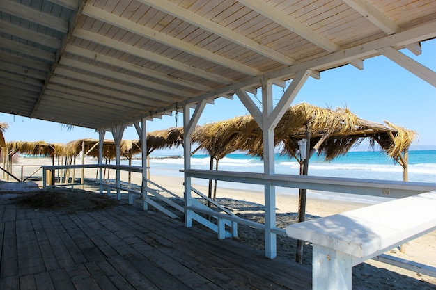 Playa vista desde una construcción de madera con techo.