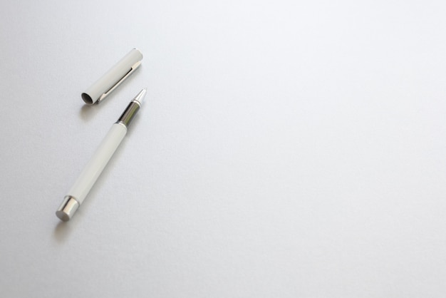 Foto gratuita una pluma blanca aislado en papel de escribir blanco, fondo.