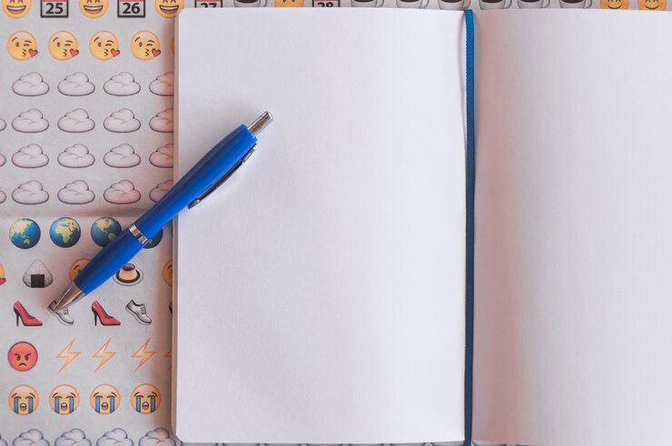 Foto gratuito pluma en el bloc de notas y emoji