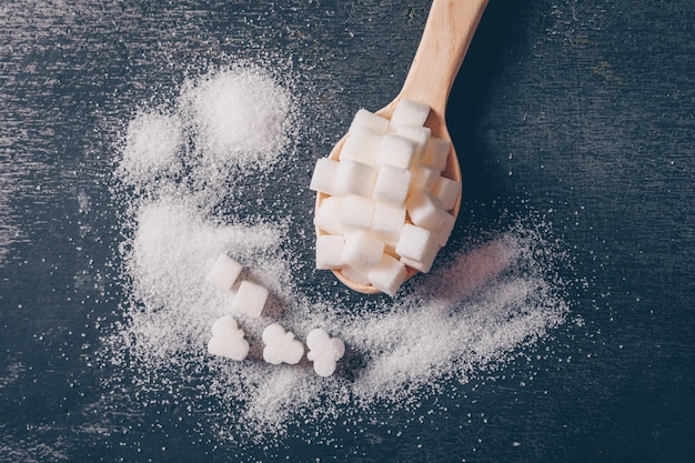 Un poco de azúcar blanca en una cuchara, plana.