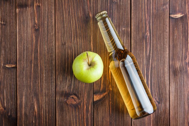 Un poco de manzana verde con jugo de manzana sobre fondo de madera, endecha plana. espacio para texto