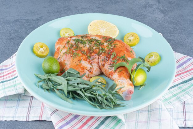 Pollo adobado con estragón de limón sobre placa azul.