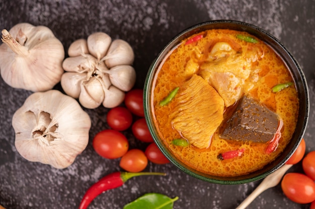 Foto gratuita pollo al curry en una taza negra.