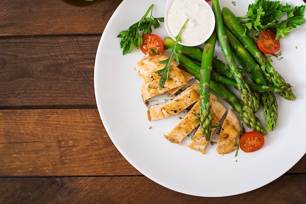 Pollo al horno con espárragos y tomates.